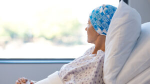 Cancer patient looking out of a hospital room window