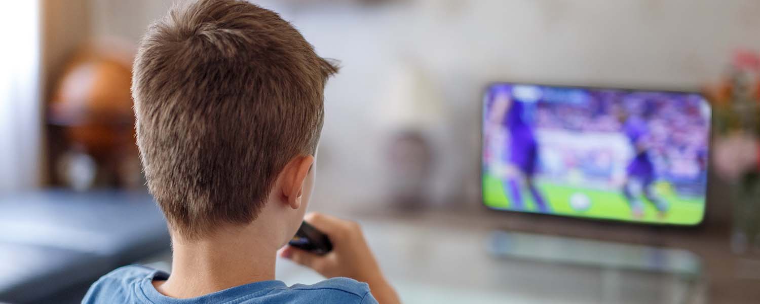 Young boy watching sport on TV