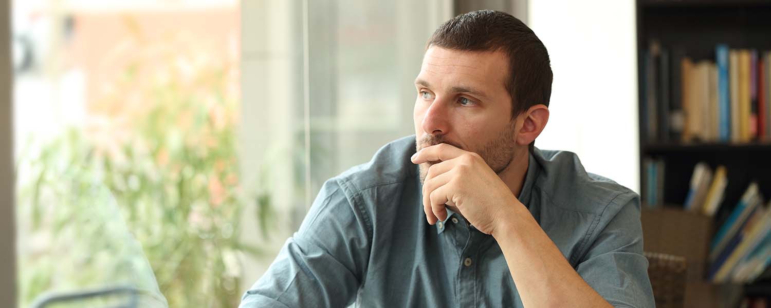 Young man sitting alone and deep in thought